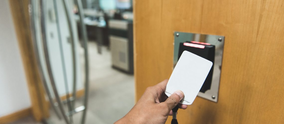 Close up hand using a card for access in to the room